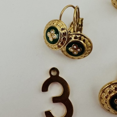 brincos dourados com detalhes verdes e número metálico 3