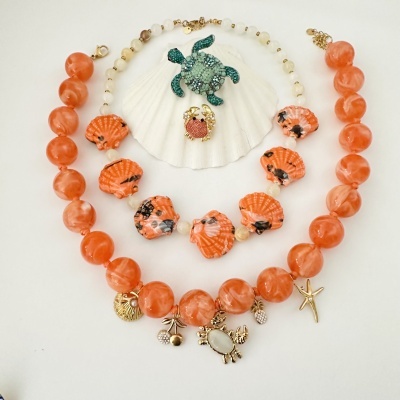 Conjunto de bijuterias coloridas com tema marinho e frutas em fundo branco