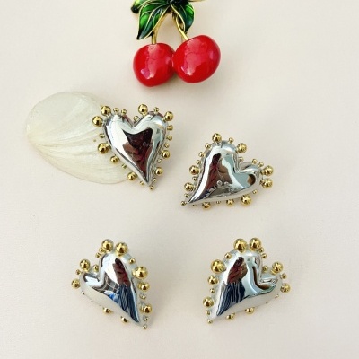 Conjunto de brincos cereja vermelha com folhas verdes e brincos em forma de coração prateado com bordas douradas