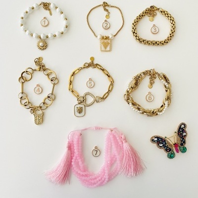 Sete pulseiras numeradas sobre fundo branco com diferentes materiais e cores.