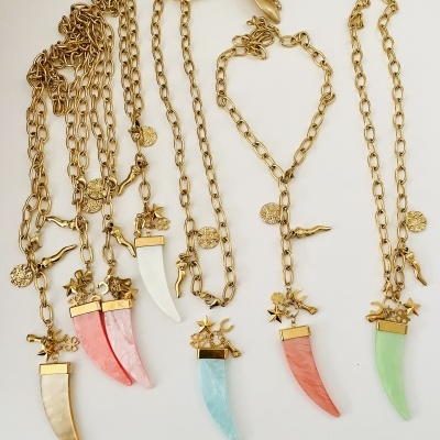 Colares dourados com pendentes de dente colorido e detalhes decorativos