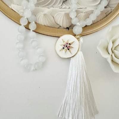 Colar com contas brancas e pendente com estrela dourada e pedras coloridas com raminho branco