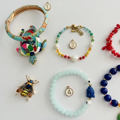 Conjunto de pulseiras coloridas e broches em fundo branco