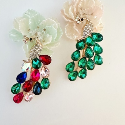 Brincos pavão com pedras coloridas e base em flor translúcida