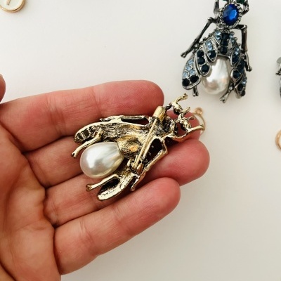 Broche em forma de inseto dourado com pérola e pedras azuis