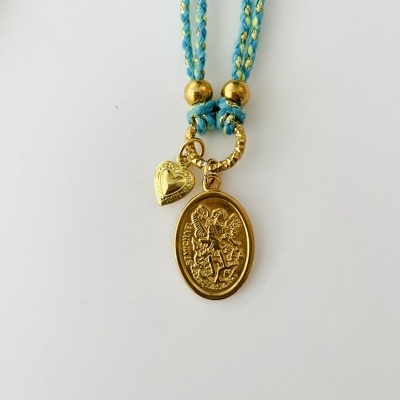 Colar com cordão azul claro e amarelo com pendentes dourados em fundo branco