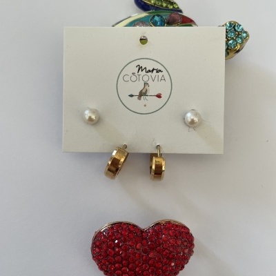 Brincos dourados argola, pérolas e brinco coração vermelho com cristais sobre cartão Maria Cotovia