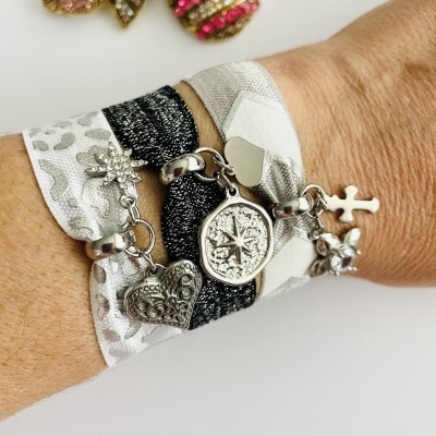 Pulseira feminina em tecido com pendentes metálicos prateados em vários formatos