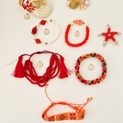 Vários acessórios de bijuteria coloridos com elementos marinhos sobre fundo branco.