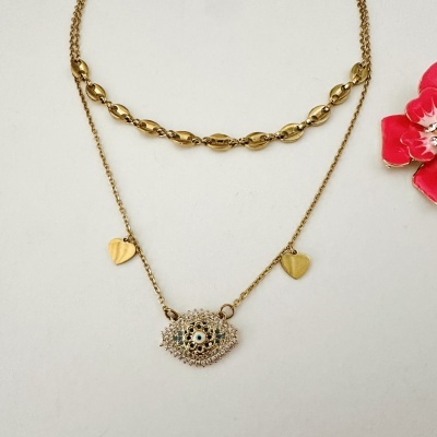 Duas pulseiras douradas com pendente em forma de olho e corações, sobre fundo branco com flor vermelha ao lado