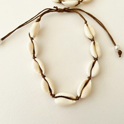 Pulseira com búzios brancos e cordão castanho