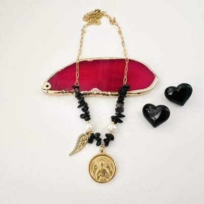 Colar dourado com pedras pretas, pérolas e pendentes religiosos, com brincos pretos em forma de coração