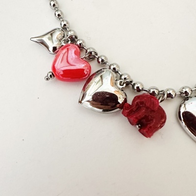 Pulseira com contas metálicas e pendentes de coração e elefante vermelhos e prateados