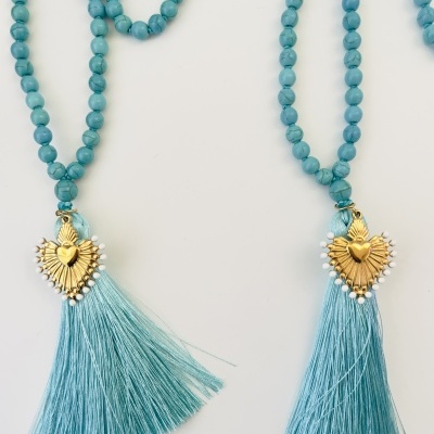 Dois colares azuis com conta e pendente em forma de coração dourado com tassel azul claro