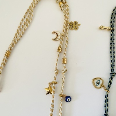 Cordões trançados bege e branco com pendentes dourados e azul