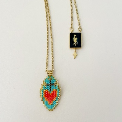 Dois colares dourados com diferentes pingentes, um colorido com contas e outro preto com figura religiosa.