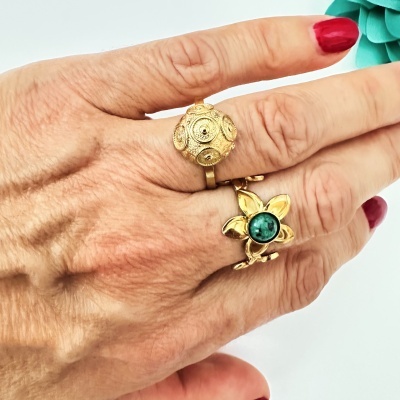 Mão com dois anéis dourados e unhas vermelhas