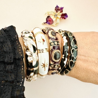Pulseiras coloridas com detalhes em dourado e broche floral roxo