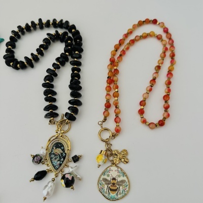 Colares com contas pretas e laranja com pendentes decorativos