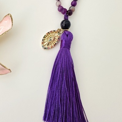 Colar com contas roxas, pendente dourado com pedras coloridas e franjas roxas