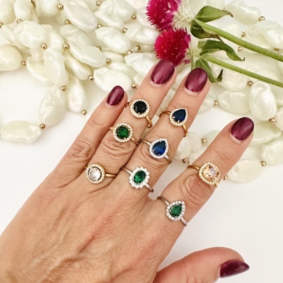 Mão com anéis coloridos e unhas vinho escuro