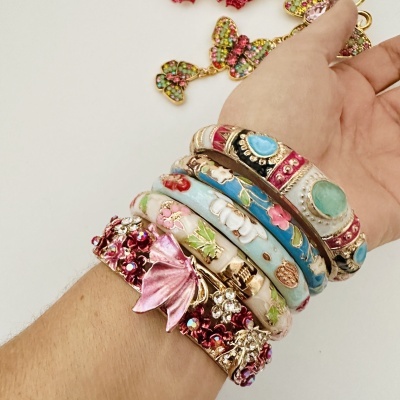 Pulseiras coloridas com detalhes florais e pedras preciosas no pulso