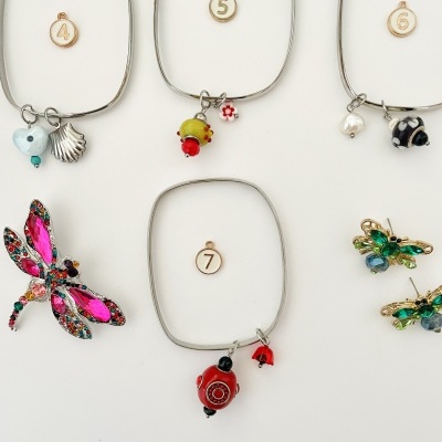 Pulseiras quadradas com pendentes coloridos em fundo branco