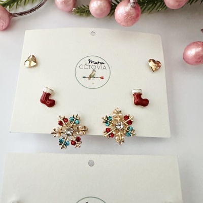Brincos de Natal em diferentes formas e cores em cartão branco com logo
