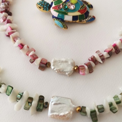 dois colares de pedras com pérolas e broche de tartaruga colorida