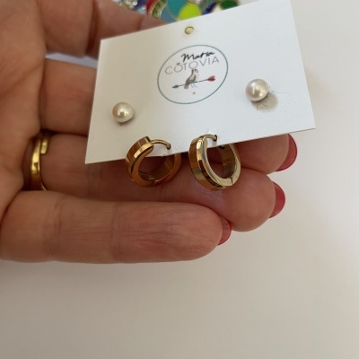 Conjunto de brincos dourados e pérolas em cartão branco com texto Maia COTOVIA