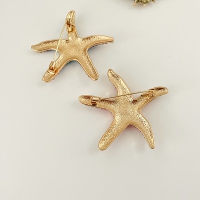 Broches dourados em forma de estrela-do-mar com textura