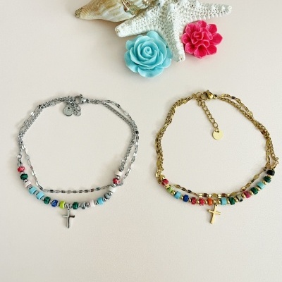 Duas pulseiras coloridas com crucifixos e decoração marinha em fundo branco