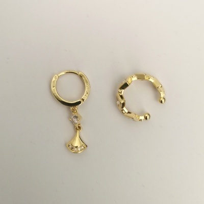 Dois brincos dourados de argola, um com pendente e outro com textura geométrica