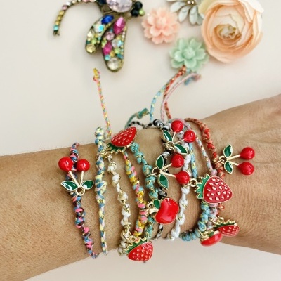 Pulseiras coloridas trançadas com cerejas e morangos vermelhos