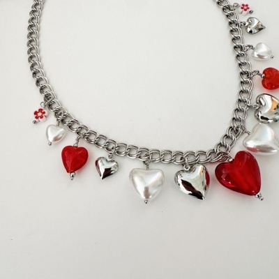 Pulseira prateada com pendentes em forma de coração e pequena flor