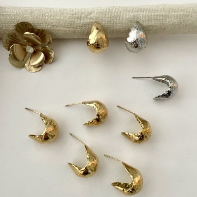 brincos de metal dourado e prateado com acabamento martelado