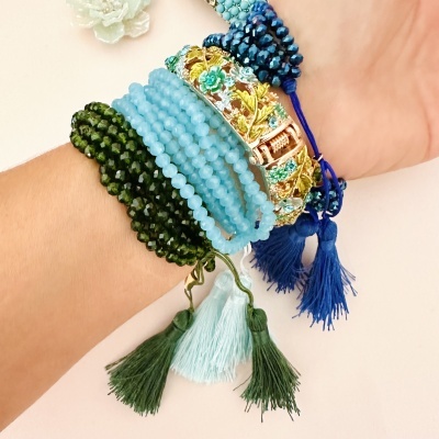 Pulso com várias pulseiras coloridas e detalhes em fios e metal decorativo