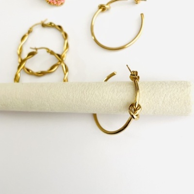 Conjunto de brincos com argolas douradas em vários estilos apoiados em fundo branco