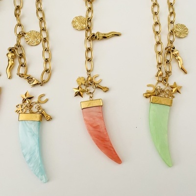 Três colares com dentes coloridos e pendentes dourados