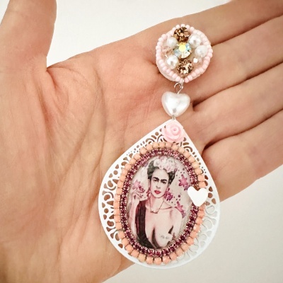 Brinco decorativo em formato gota com imagem de mulher e detalhes em pérolas e pedras rosas