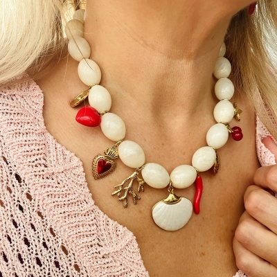 Colar de contas brancas com pendentes coloridos usado com camisola rosa