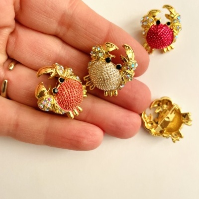 Pins de caranguejo dourados com corpo vermelho e dourado e pedras brilhantes