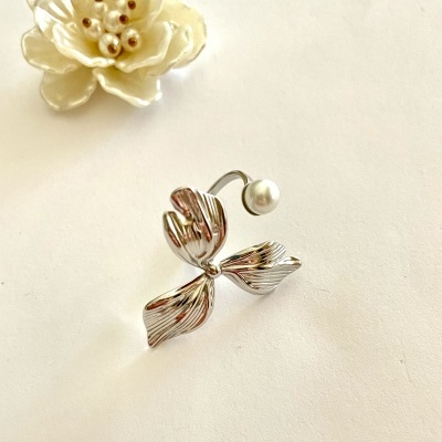 Anel prateado com design de flor e pérola artificial em fundo claro.