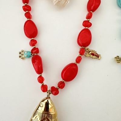 Colar com contas vermelhas, perninhas douradas e pingente de peixe dourado