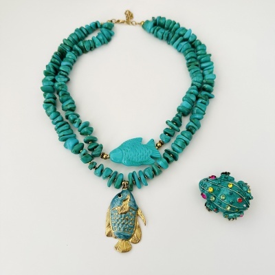 Colar turquesa com pingente de peixe e broche verde de cactus com pedras coloridas.