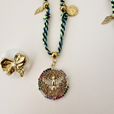 Colar com pendente metálico colorido e anel flor dourada com pérola sobre fundo branco