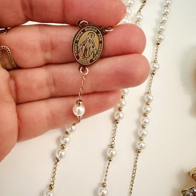 Rosário com contas brancas e medalha dourada da Virgem Maria