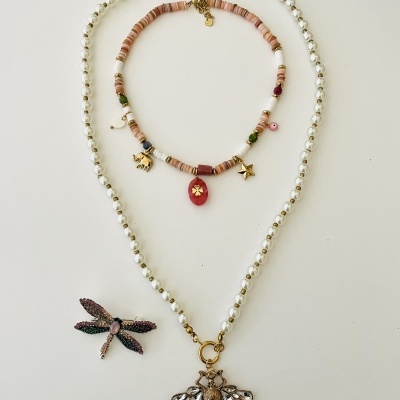 Colares com pérolas e contas coloridas e um broche de libélula