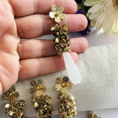 Brincos dourados com flores metálicas e pendente de pedra branca