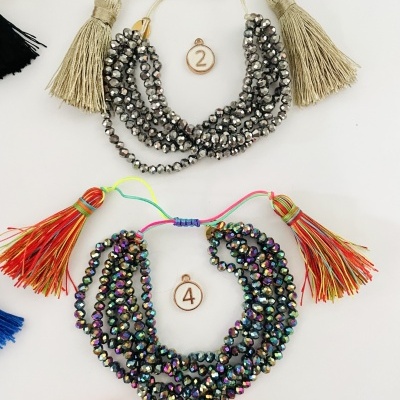 Duas pulseiras coloridas com contas brilhantes e franjas, etiquetas numeradas 2 e 4